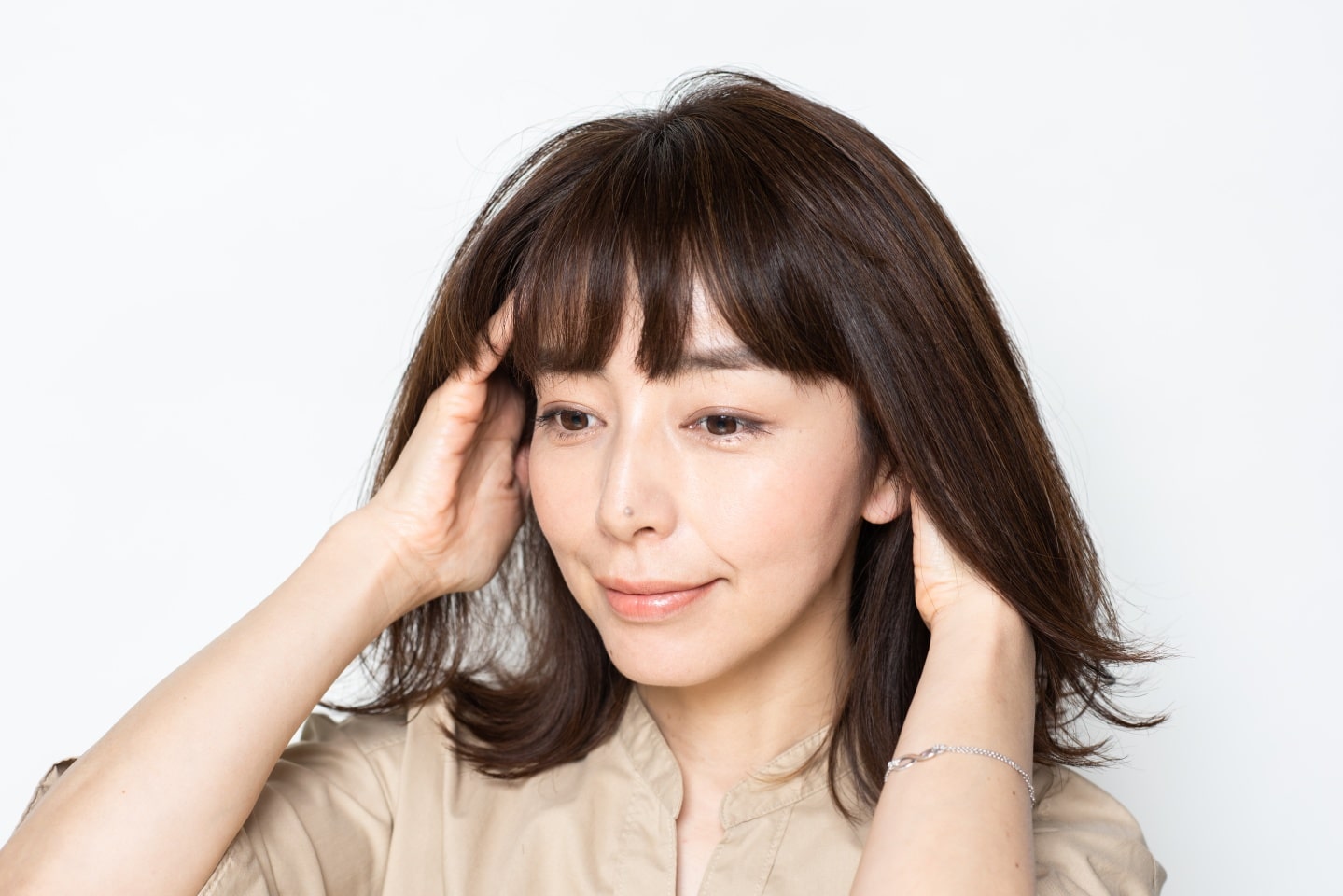 オイル系かクリーム系のスタイリング剤を手のひらにのばし、髪の内側を中心になじませる。つけすぎ注意。