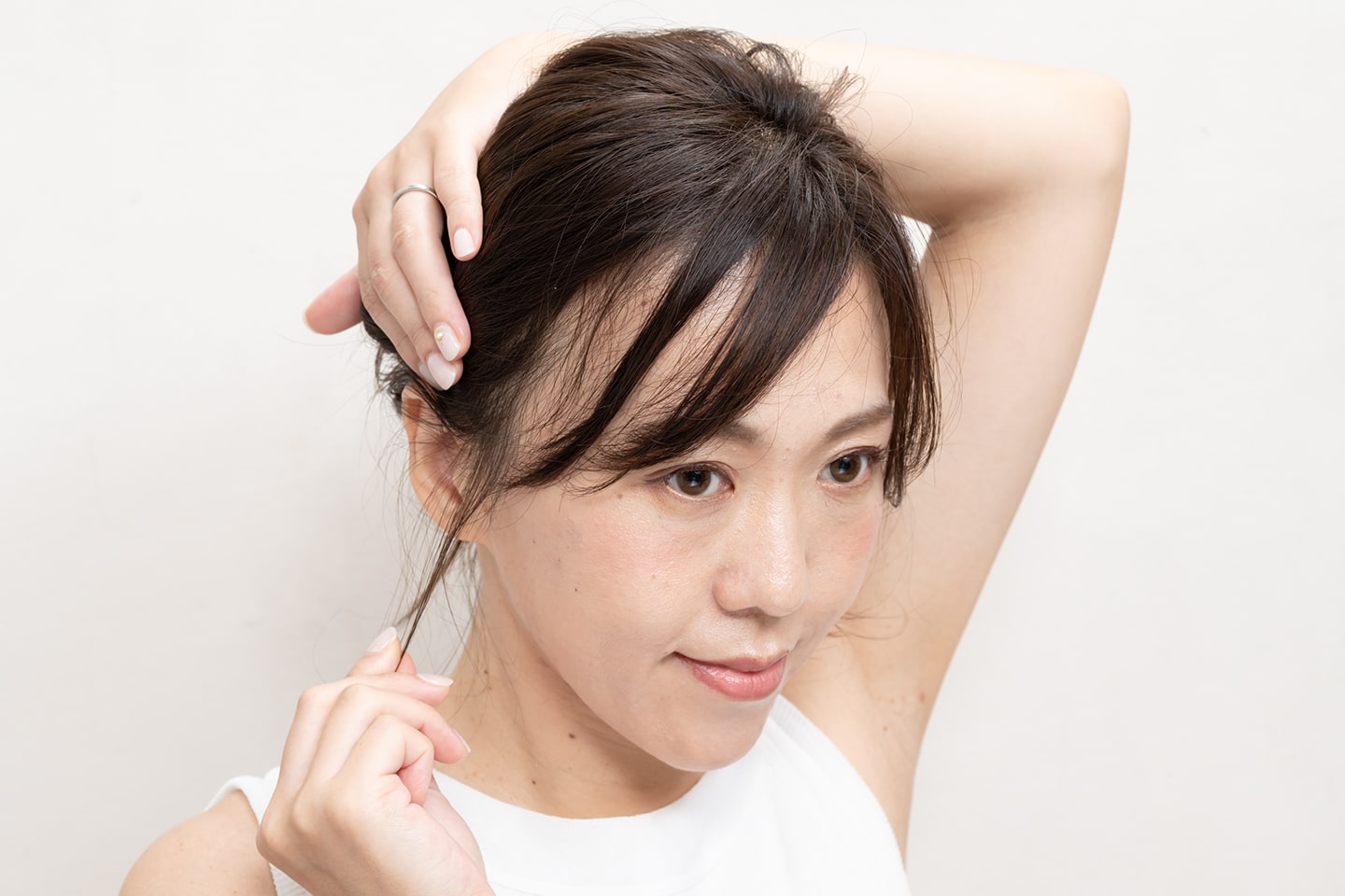 爪の先でこめかみの毛束を少しだけつまみ、引き出す。