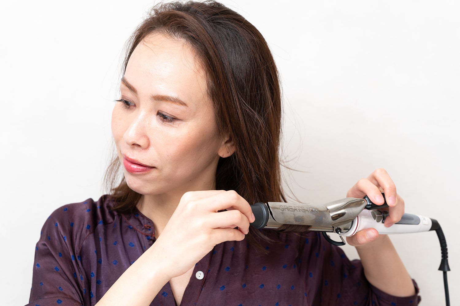 コテは28mmを使用。毛束をランダムに取って毛先をすべて外ハネにする。