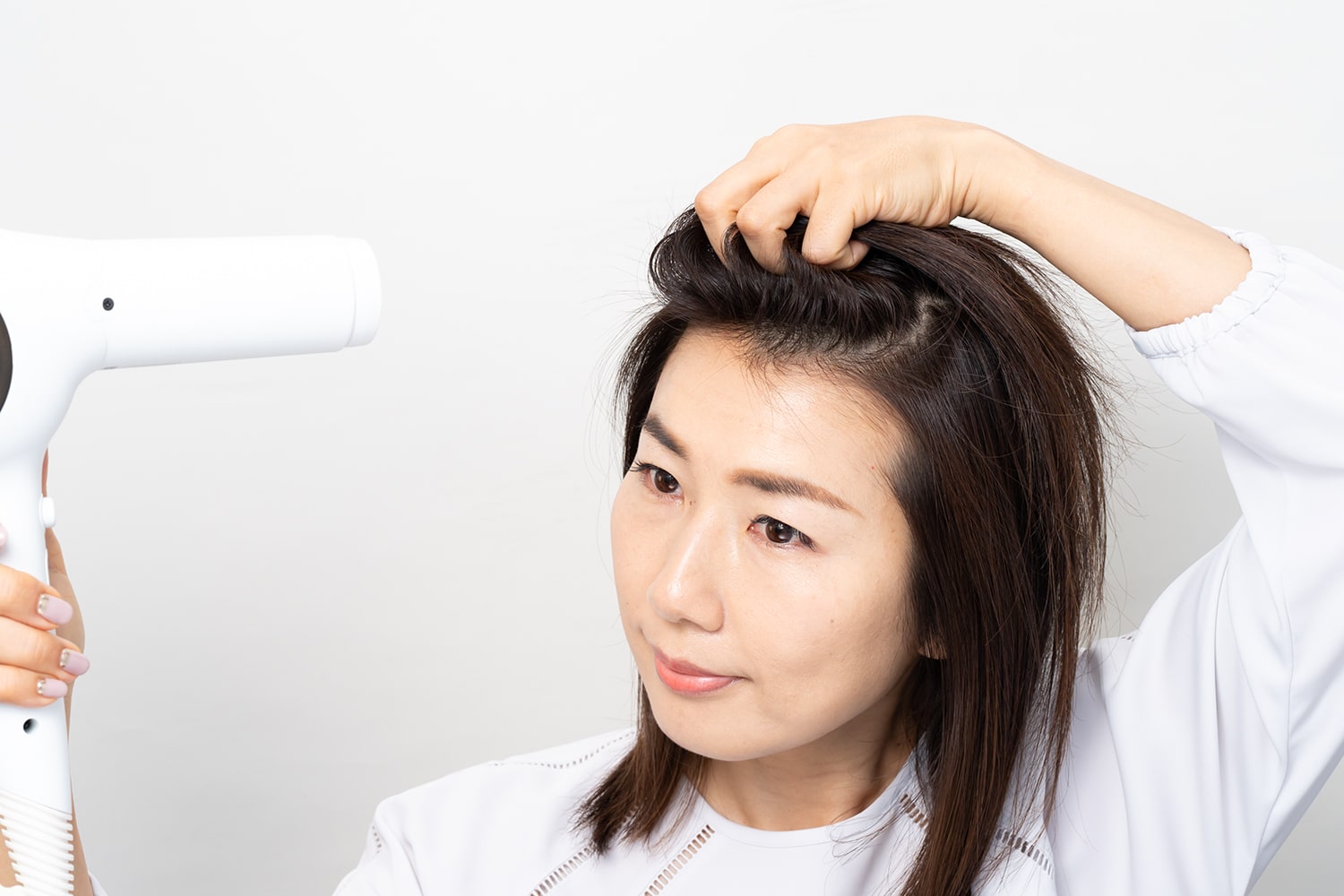 分け目をまたぐように髪を握り、根元を浮かせながら前に倒すこと。