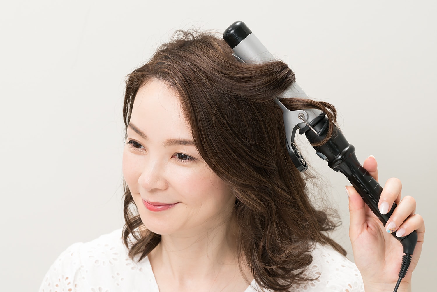 ランダムに毛束をとり、髪全体を外巻きにする。