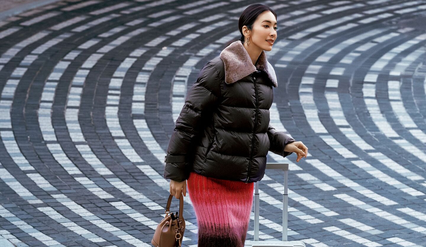 「フェンディ」のダウンとニットスカートを着用したモデル