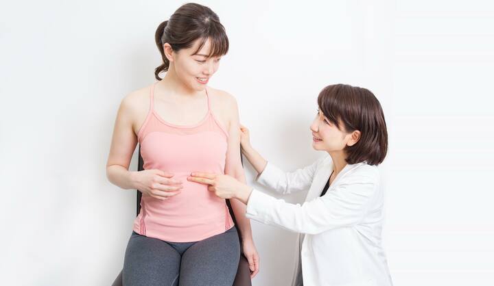 並んでいる二人の女性 マッサージの指導をしている