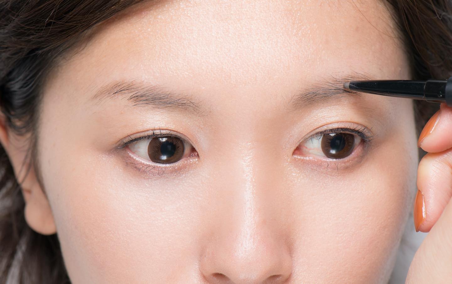 左右の眉で高い方は下を、低い方は上を中心に描き足していくとシンメトリーな仕上がりに。
