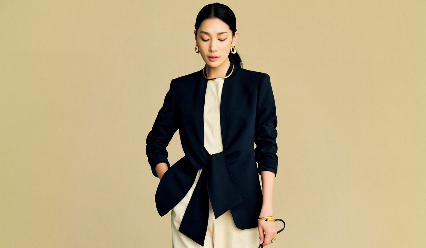 「マックスマーラ」のノーカラージャケットと「ジア スタジオ」のオールインワンを着用したモデル