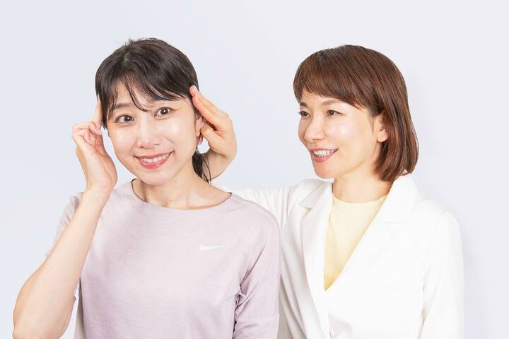 二人の女性 ツボ押しの指導をしている