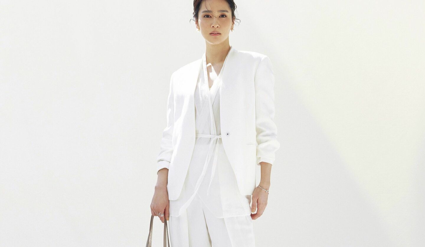 「ブルネロ クチネリ」のオールホワイトのパンツスタイルを着用したモデル