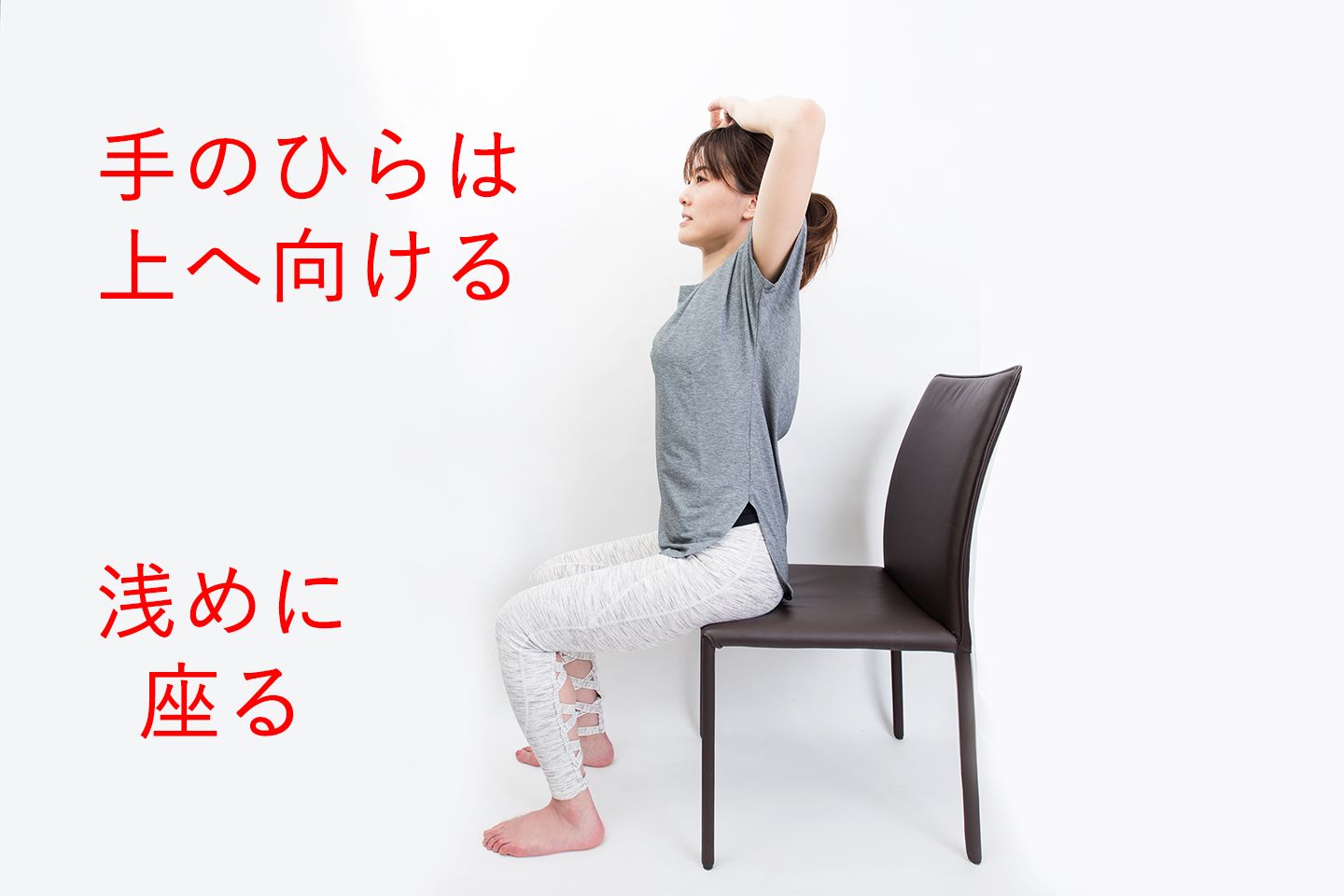 椅子に浅く座り、組んだ手の甲を頭にのせる