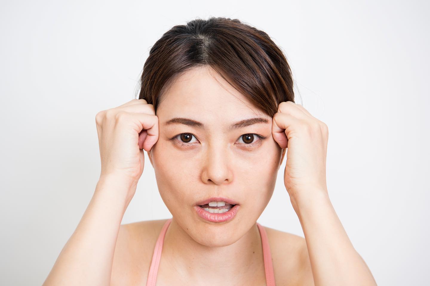 こめかみにこぶしを当てる