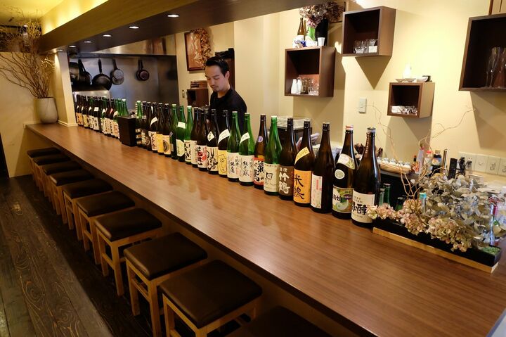 店主の大石航平さん。店に入るとカウンターに日本酒がずらり