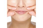 両手の人さし指と親指を使い、ほうれい線をつまみ口周りの筋肉をほぐす。