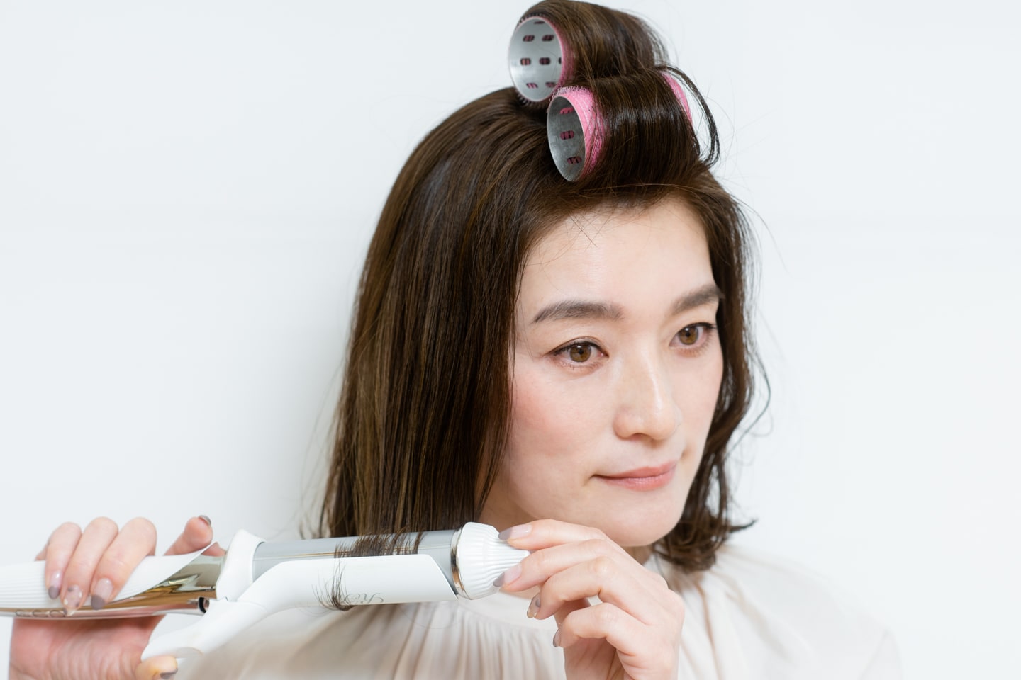 32mmのヘアアイロンを使用。全体の毛先をすべて半回転巻いて外ハネにする。