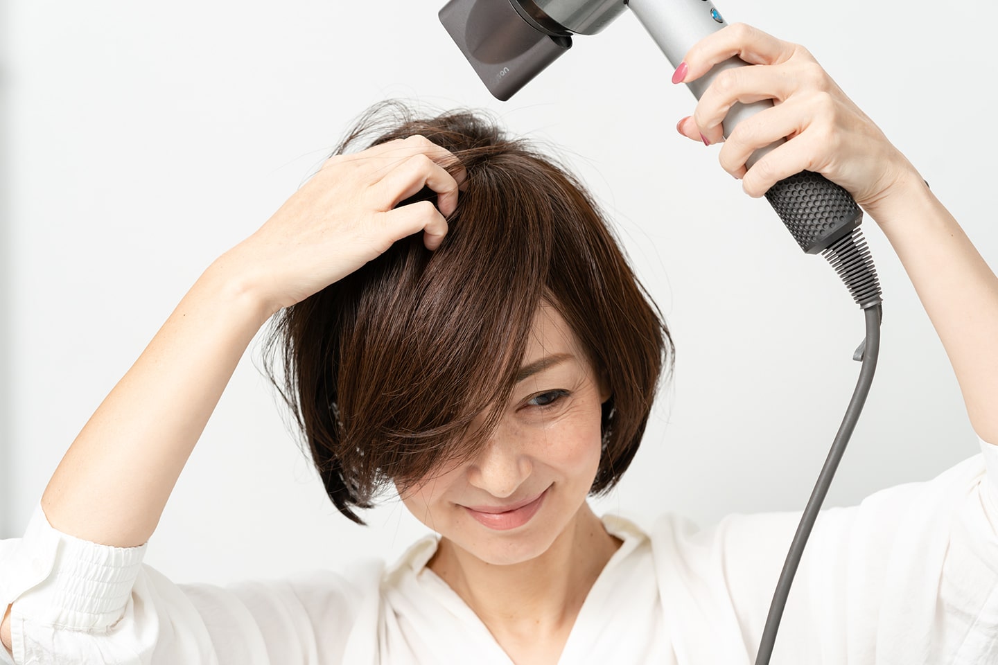 いつもの分け目とは逆方向に手ぐしでとかしながらドライヤーをあてる。