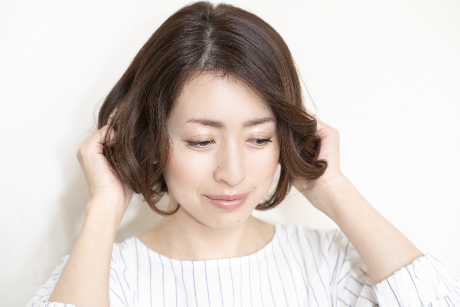 オイルバターを手のひらになじませ、髪の中間~毛先にもみこんで束感を出す。