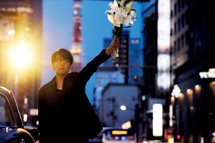 花束を手にした音楽家の岡村靖幸さん