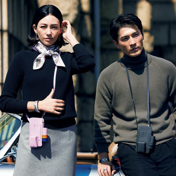 スマートフォン、イヤフォン、カード、リップスティックをまとめて収納できるケースは、利便性はもちろん〝エルメス〟らしい洒落たカラーにも惹かれて。「パートナーと贈り合って、身軽で自由な休日を楽しみたい」とリタさん。［レディス］スマートフォンケース『エルメスウェイ』［縦16.5×横8.7×マチ2.2㎝］￥316,800•スカーフ￥57,200•ピアス￥101,200•ブレスレット［手首側から］￥66,000•￥102,300（エルメスジャポン） ニット￥29,700（スローン） スカート￥99,000（ブラミンク） ［メンズ］スマートフォンケース『エルメスウェイ』［縦16.5×横8.7×マチ2.2㎝］￥299,200•ブレスレット￥119,900•リング￥39,600（エルメスジャポン） ニット￥157,300（ボーダレス〈スコット アンド チャーターズ〉） パンツ￥49,500（トヨダトレーディング プレスルーム〈ラルディーニ〉）