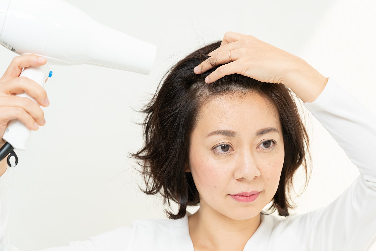 手ぐしで髪の根元をとかしながらドライヤーで乾かす。