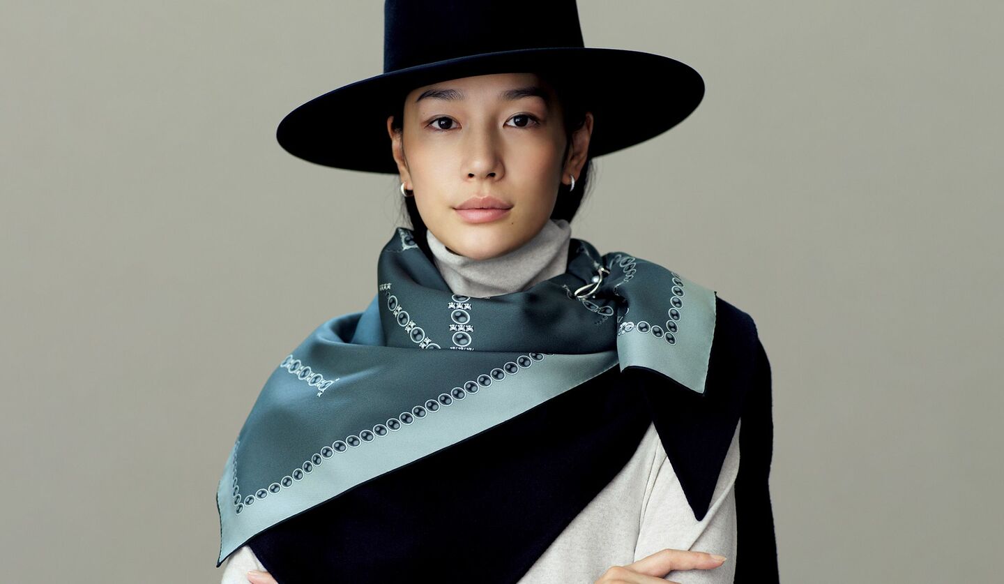 柄スカーフに無地ストールをレイヤードしたモデルの大塚まゆかさん