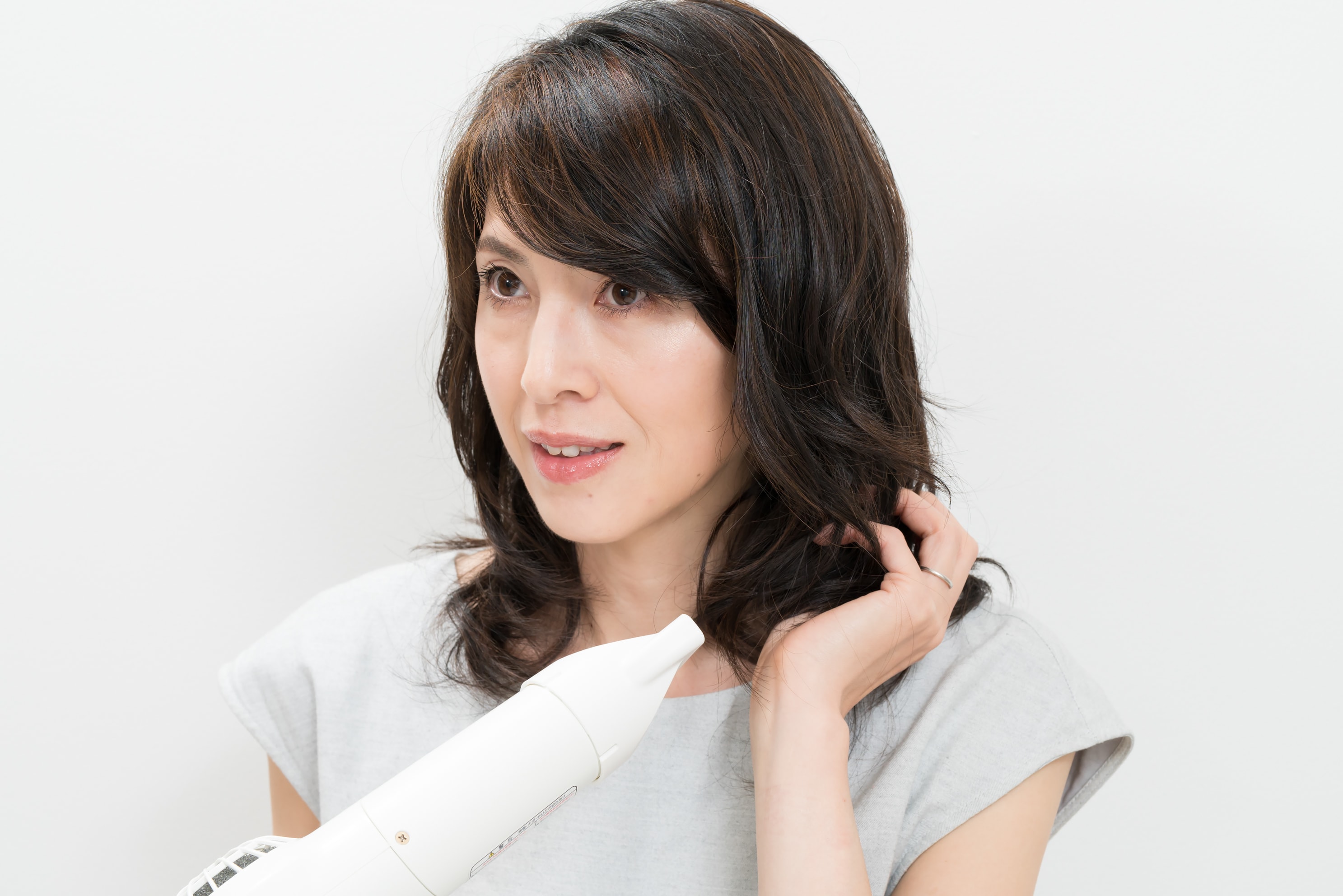 ドライヤーはブローをするときと同じ温度で、左右の毛束を2~3回くらいずつ握ってクセをつけます