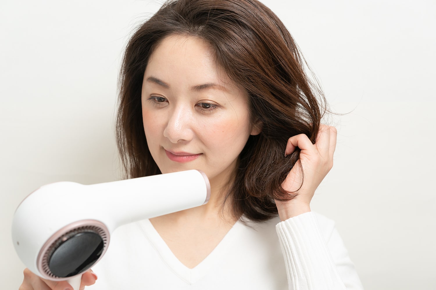 髪の中間から毛先にかけてクシュクシュと握りながらドライヤーをあてる。