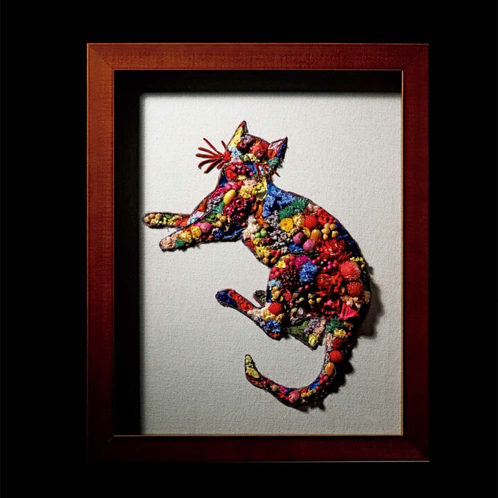 花を贈りたい相手がもし猫を愛する人だったら？ オーダーメイドフラワーアートという素敵な花の贈り方を提示してくれるのは、花や植物の可能性を広げるべく、枠にとらわれないさまざまな表現で活動する今泉冴也香さんだ。華やかさをもたせながら、男性でも贈りやすいような雰囲気に仕上げたというこのアート作品は、ポップアートの巨匠、アンディ・ウォーホルが日常から描いていた猫がモチーフ。特殊加工により長期保存を可能にしたプリザーブドフラワーとドライフラワーをベースに、アーティフィシャルフラワー（造花）を織り交ぜて仕上げている。世界にひとつだけの花を贈りたい人へ。￥16,000～［額縁込み］（MY’S）