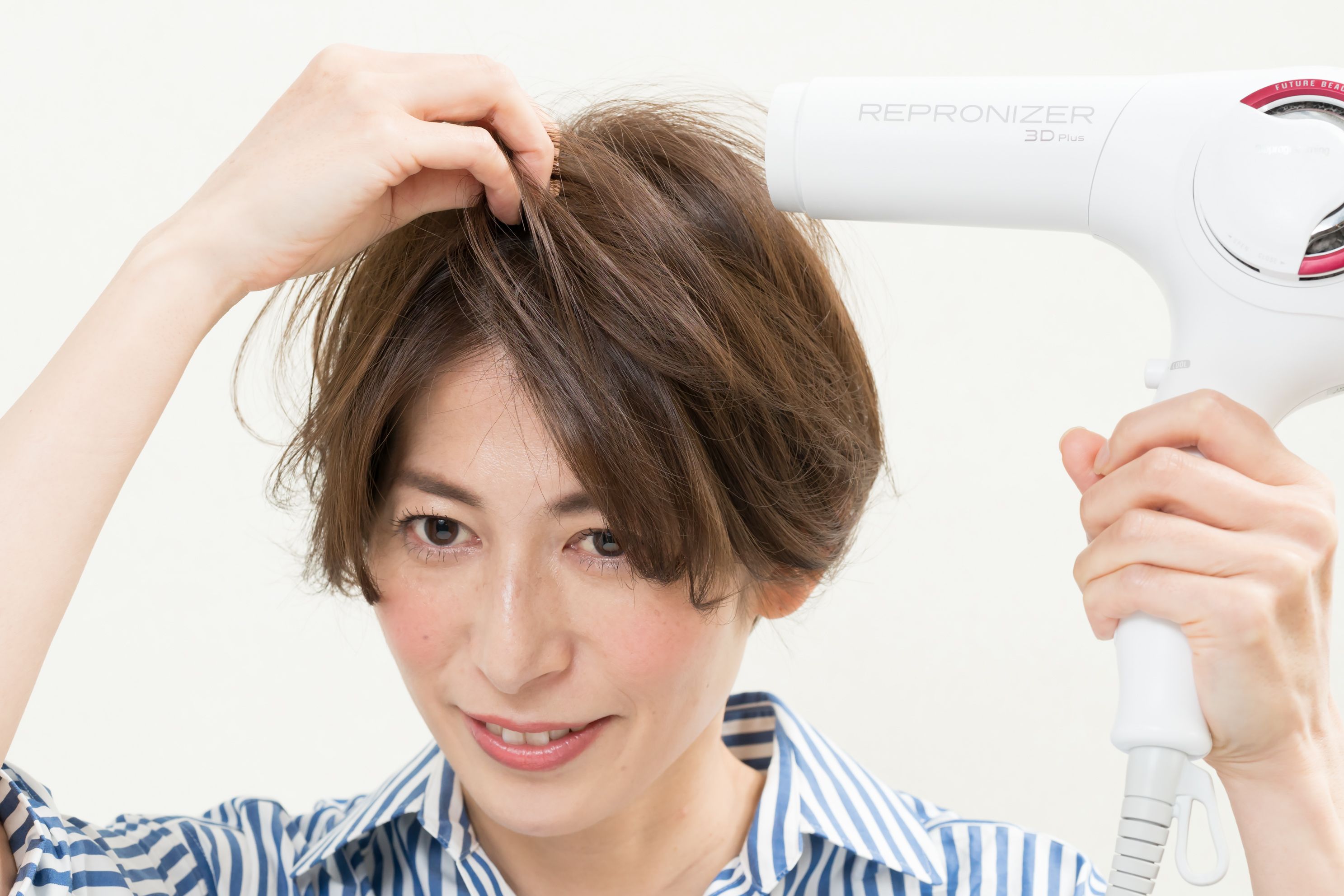 ドライヤーは根元に向けて、下から上に髪を立たせるように熱を当てる。