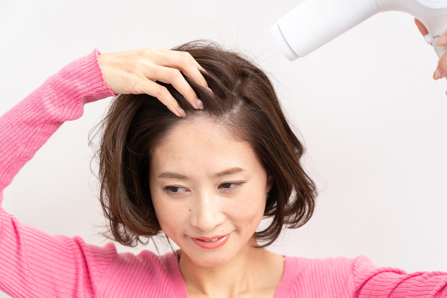 分け目と逆方向から乾かすことで、トップがふんわりと立ち上がる。熱風は根元に当てるのが正解。