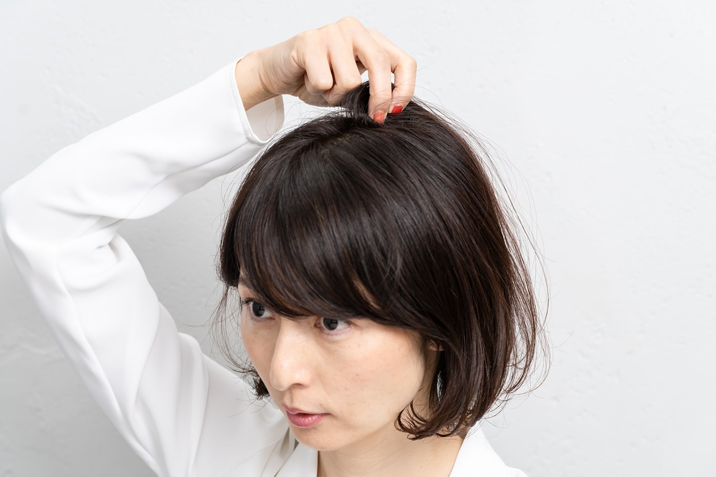 ボリュームがほしい部分の髪の根元を、バランスを見ながらつまみ上げる。