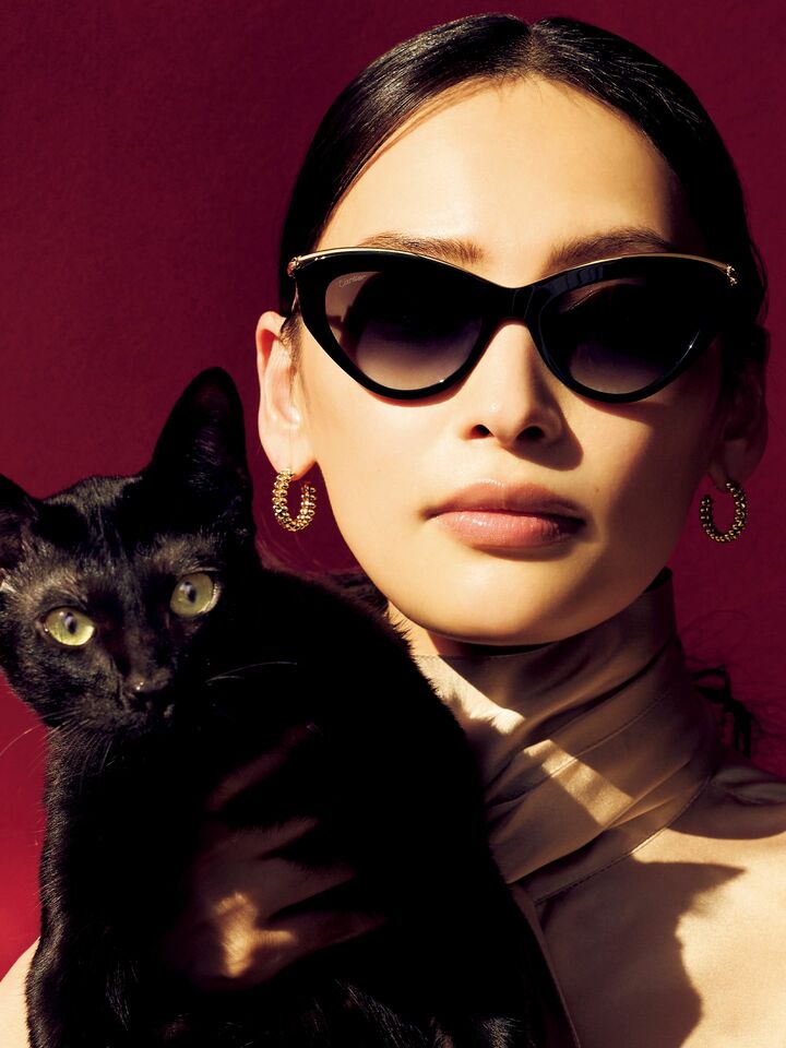 「カルティエ」のサングラスを着用したモデルの大政 絢さんと猫