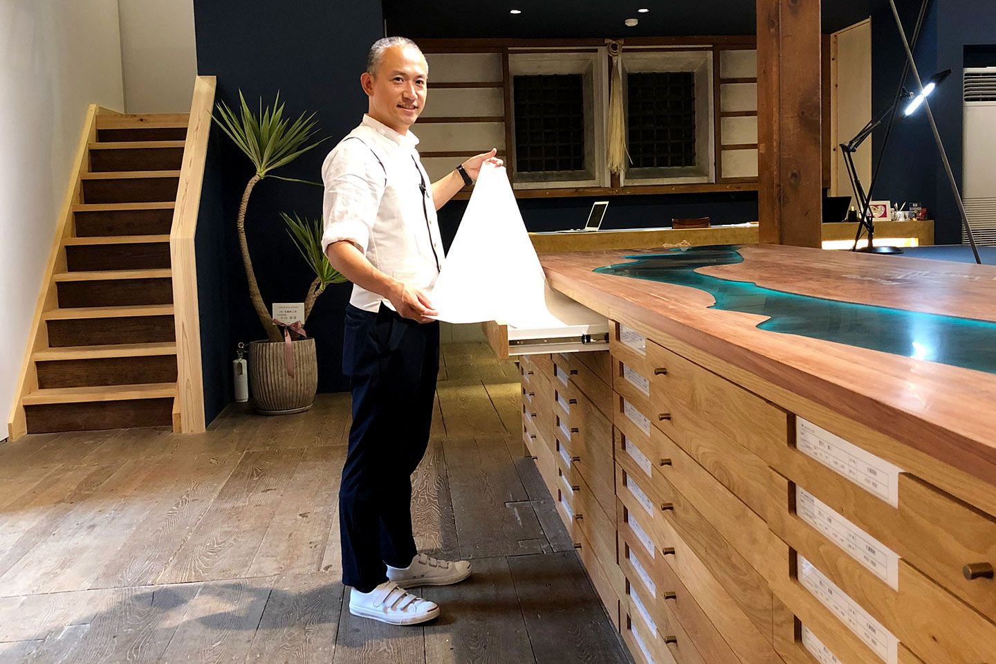 美濃和紙メーカー丸重企業製紙組合の3代目理事、辻 晃一さん。右の机には、岐阜を象徴する長良川の支流である、板取川をイメージした装飾が施されています