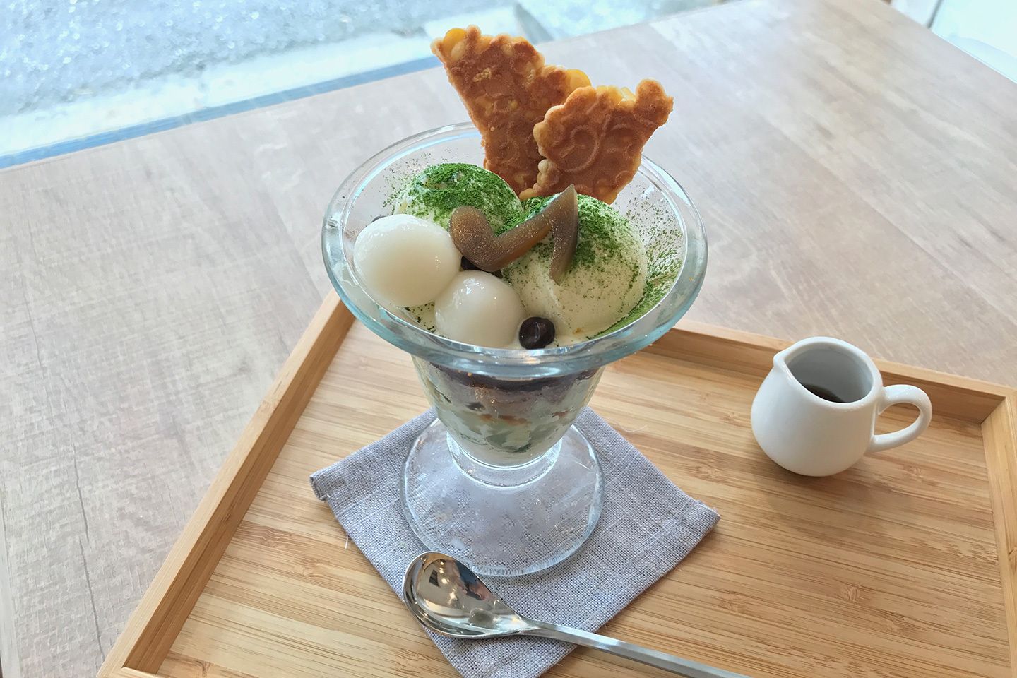 お煎餅が添えられた「抹茶パフェ」¥864 (税込)。元住吉の店舗限定でようかんでつくられた音符がついています。