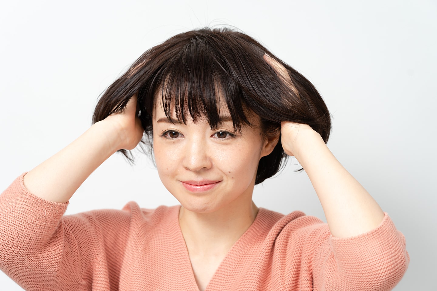 内側から揉み込んだあと、手に残ったバームを髪の表面になじませる。