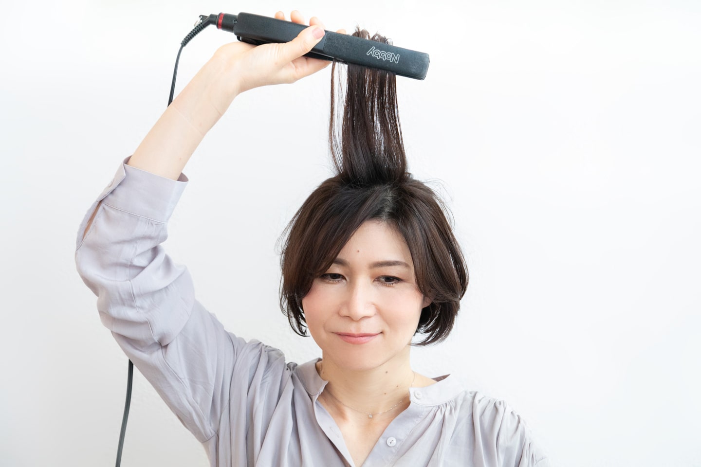 ストレートアイロンを、髪全体に通して毛先に丸みをつける。トップは上に持ち上げながら滑らせて。