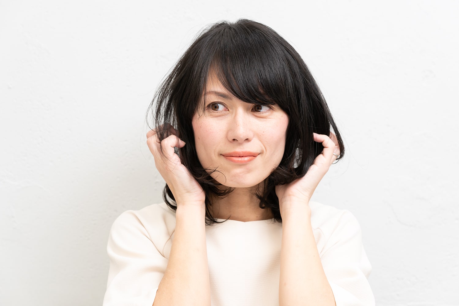 ワックスを両手のひらに広げ、髪の中間から毛先を揉み込みながらなじませる。