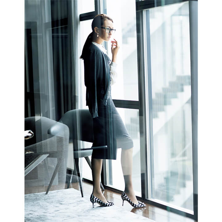 靴／上の写真［下］と同じ、カーディガン￥146,000（サードカルチャー〈マチルダ カシミヤ〉）、ブラウス￥28,000（サザビーリーグ〈エキップモン〉）、スカート￥30,000（アノア〈リビアナ・コンティ〉）、ピアス￥121,700／参考価格（ステディ スタディ〈ソフィー ビル ブラーエ〉）、眼鏡￥48,000（ミラリ ジャパン〈スタルク アイズ〉）　[Precious2019年1月号216-17ページ] 　