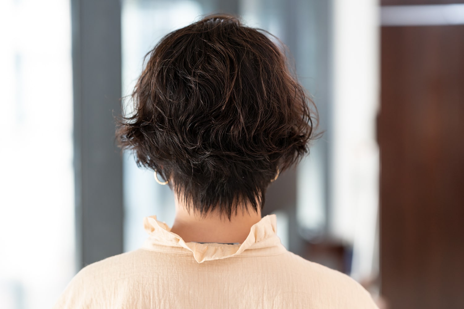 髪のコシがなく、すぐにペタッとしがちなモデルさんの髪。「髪に厚みを出すためにレイヤーは入れていません。ただ、動きが出やすくなるようリップラインに合わせて長さを調整しました。華やかな雰囲気になるよう、毛先を中心にパーマをかけています。パーマをかけるだけで、ご自身でもアレンジしやすくなるはずです」(嶋根さん)