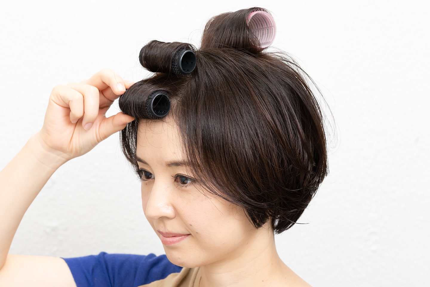 上段の毛束は根元を立ち上げながら、下段は毛束を真っ直ぐ前に引っ張りながら巻くこと。