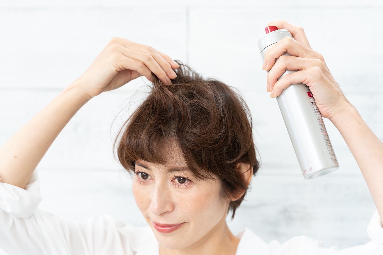 頭頂部の毛束をつまんで根元にスプレー。根元の立ち上がりをキープすることができる。