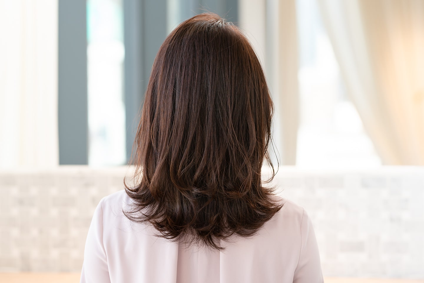 やや硬めの髪でボリュームが多いモデルさんの髪質。「髪が硬く、量が多くてもレイヤーを入れることでシルエットが軽くなるので、すっきりとしたスタイルになります。友澤さんとは真逆の髪が細くて毛量の少ない人でも、このスタイルならボリュームを出しやすくなるのでおすすめです」(徳永さん)