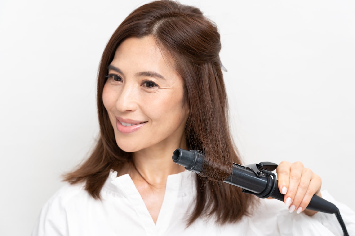 サイドからバックまで同様に、中間部からアイロンを通して1カールさせる。