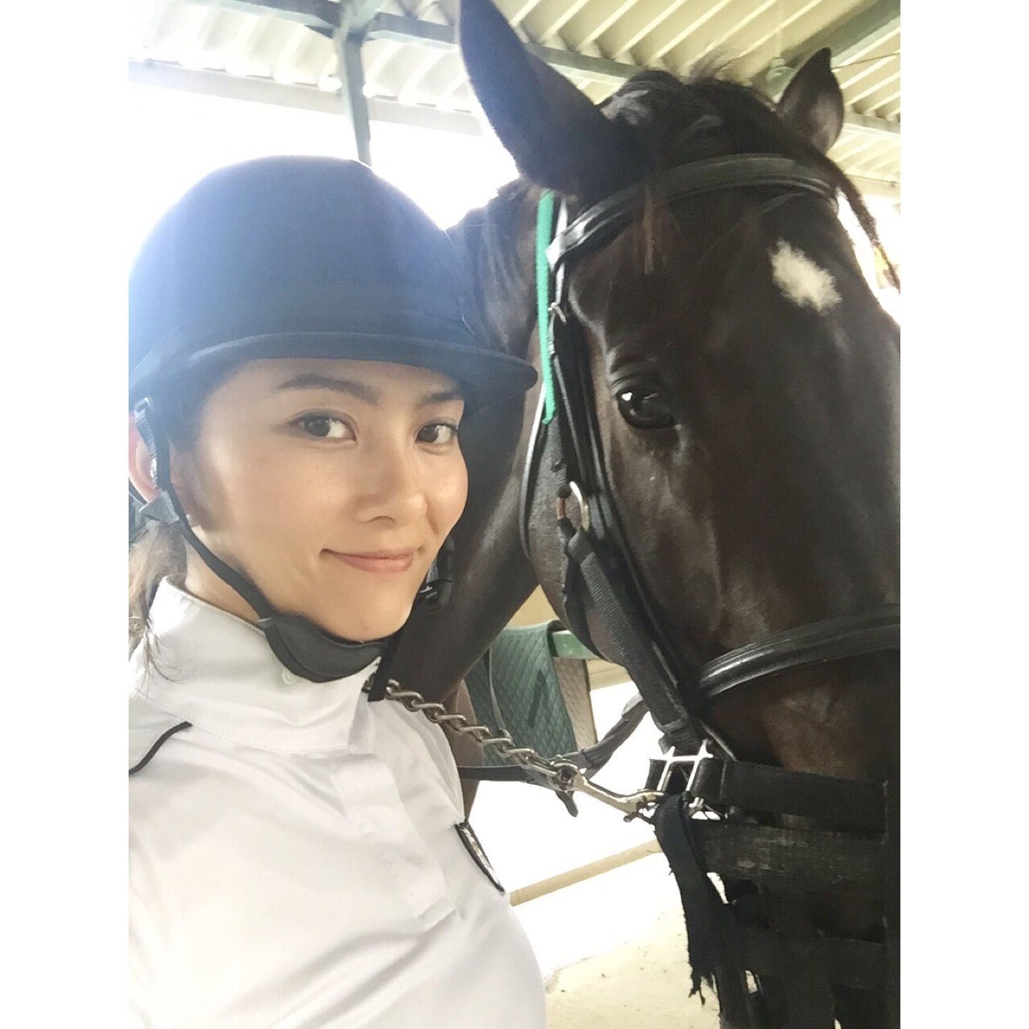 ヘルメットを被り、馬と写る白澤さん