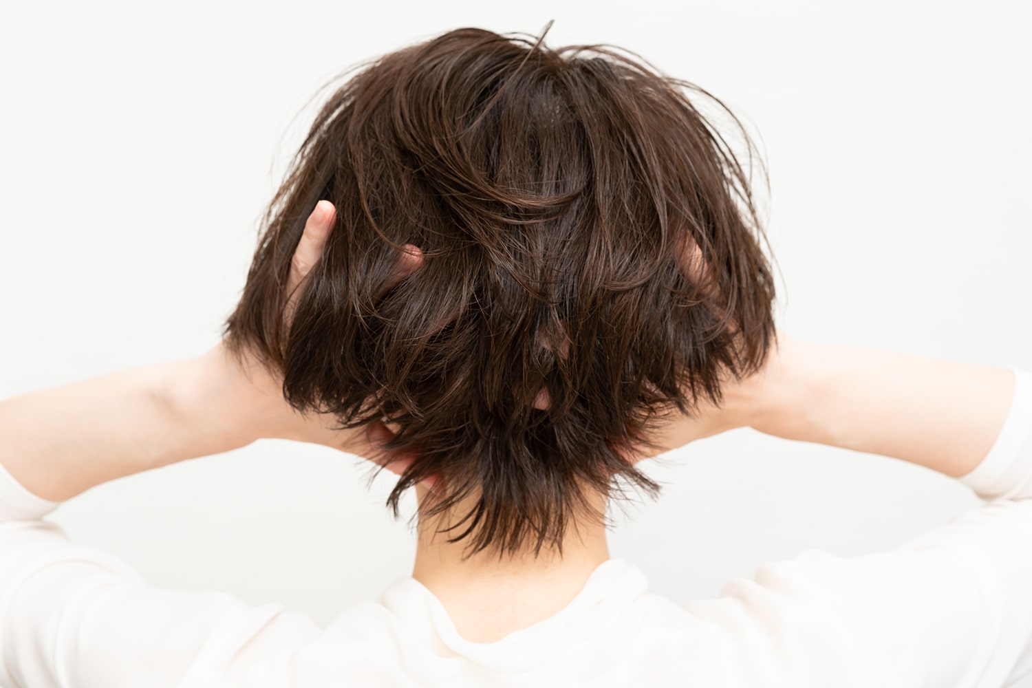 もう一度パール粒ひと粒大のワックスを手のひらになじませて、後頭部の内側へよく揉み込む。