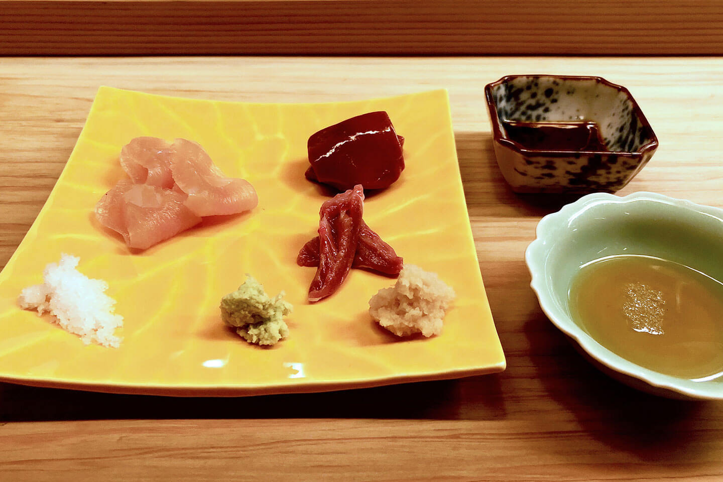 鮮やかな皿に合わせた3種の刺身。左「ムネ肉の昆布締め」、右奥「レバー」、右手前は「ハツ」