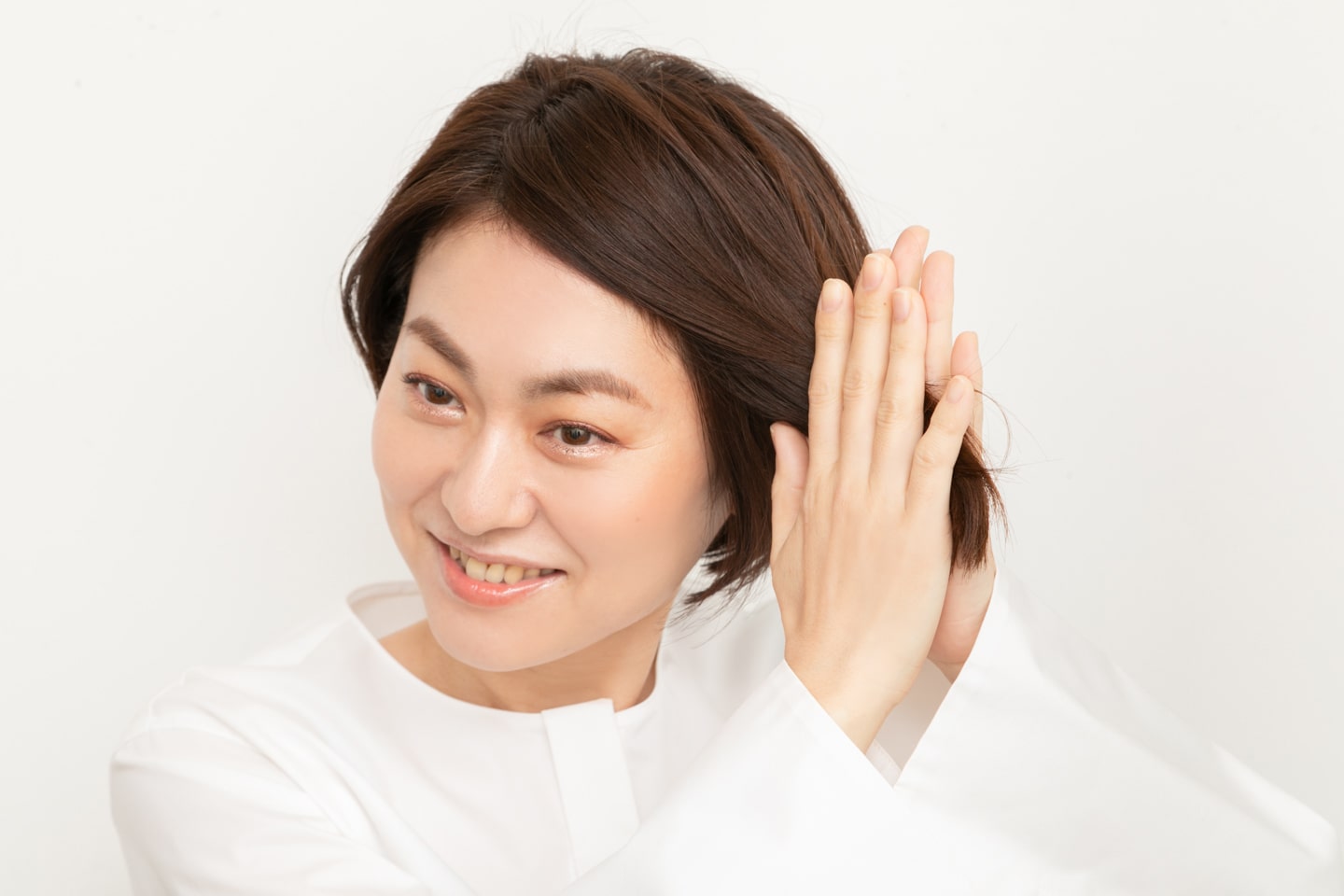 毛先を中心にヘアオイルをつけたら、手に残った分を全体になじませてツヤを出す。