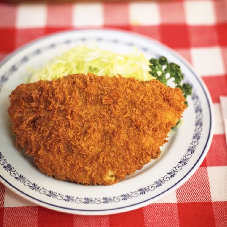 元祖ポークカツレツ1700円。熱々の状態で供されるカツレツにナイフを入れた瞬間、何とも言えない芳香が立ち上り食欲をそそる。健気なまでに実直な姿のカツレツは、いつ何時味わっても常に新鮮な味がする。それは左の元祖ハヤシライス1800円も同様。老舗の矜持を感じる。