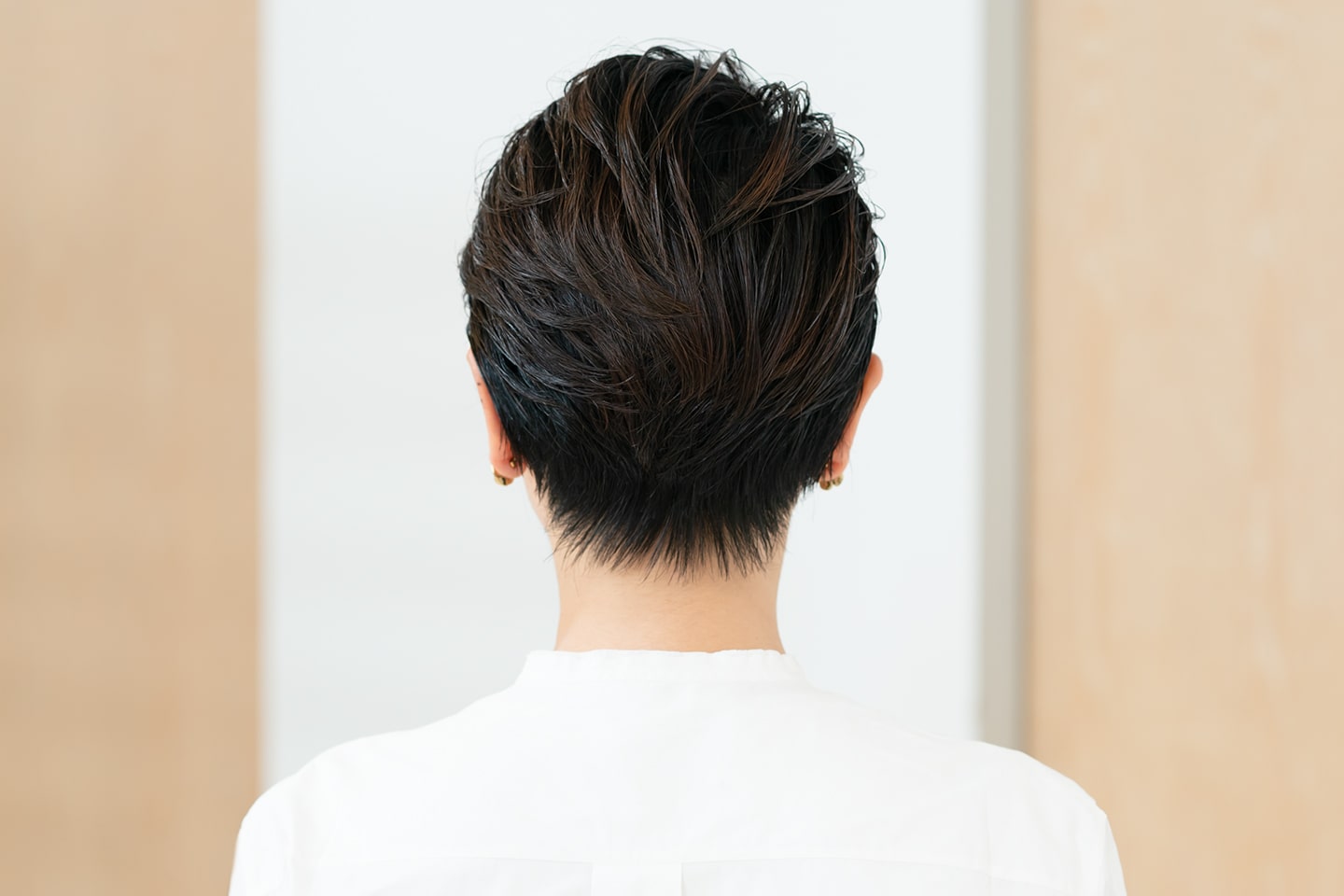 クセとうねりがあり、1本1本が太くて毛量が多いモデルさんの髪。「頭頂部から後頭部にかけて根元を立たせるようにカーラーで巻いておけば、ボリューム感が出せます。トップがペタンコになりやすい方にもおすすめのスタイルです。毛量は内側で調整して、表面にツヤを出しやすくしています。うねりやクセはアイロンなどで伸ばすのではなく、あえて生かすようにスタイリングすると動きが出せます」(山岸さん)
