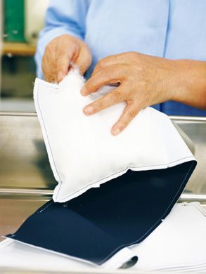 保温性を左右するダウンパ ックの製作風景。こちらもひとつひとつ、手作業でフ ェザーを充塡している。