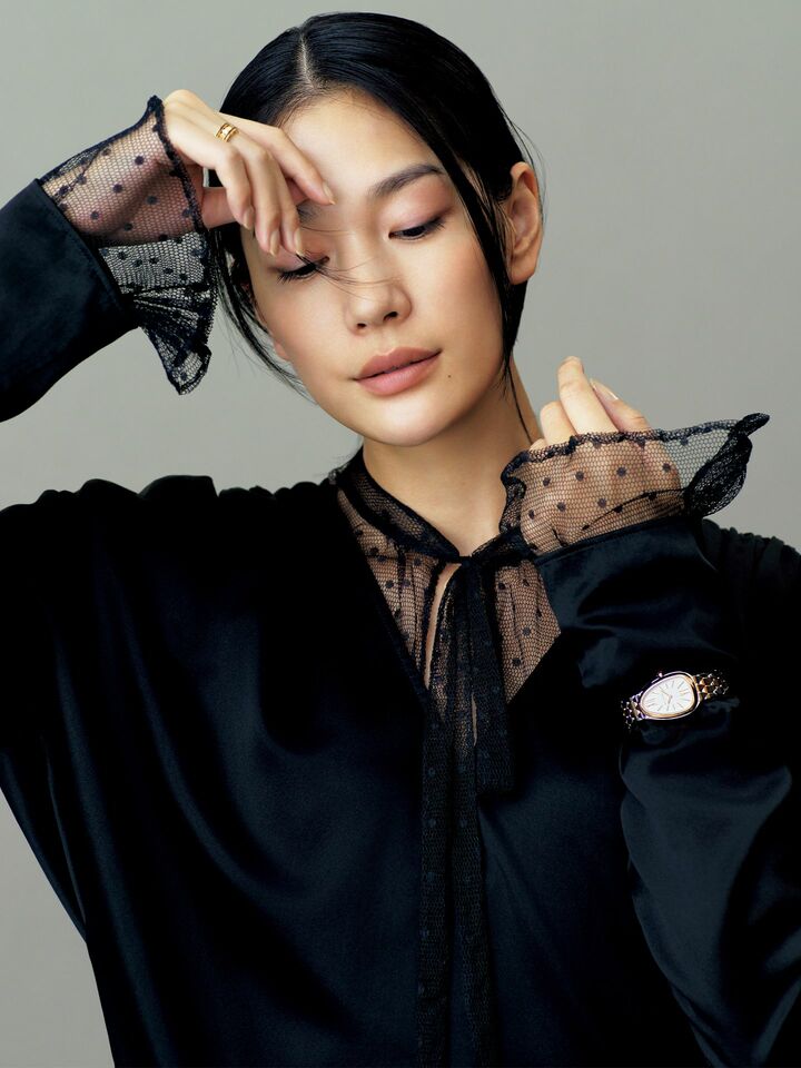 ボウタイブラウスにVネックブラウスを重ねたモデルの大塚まゆかさん