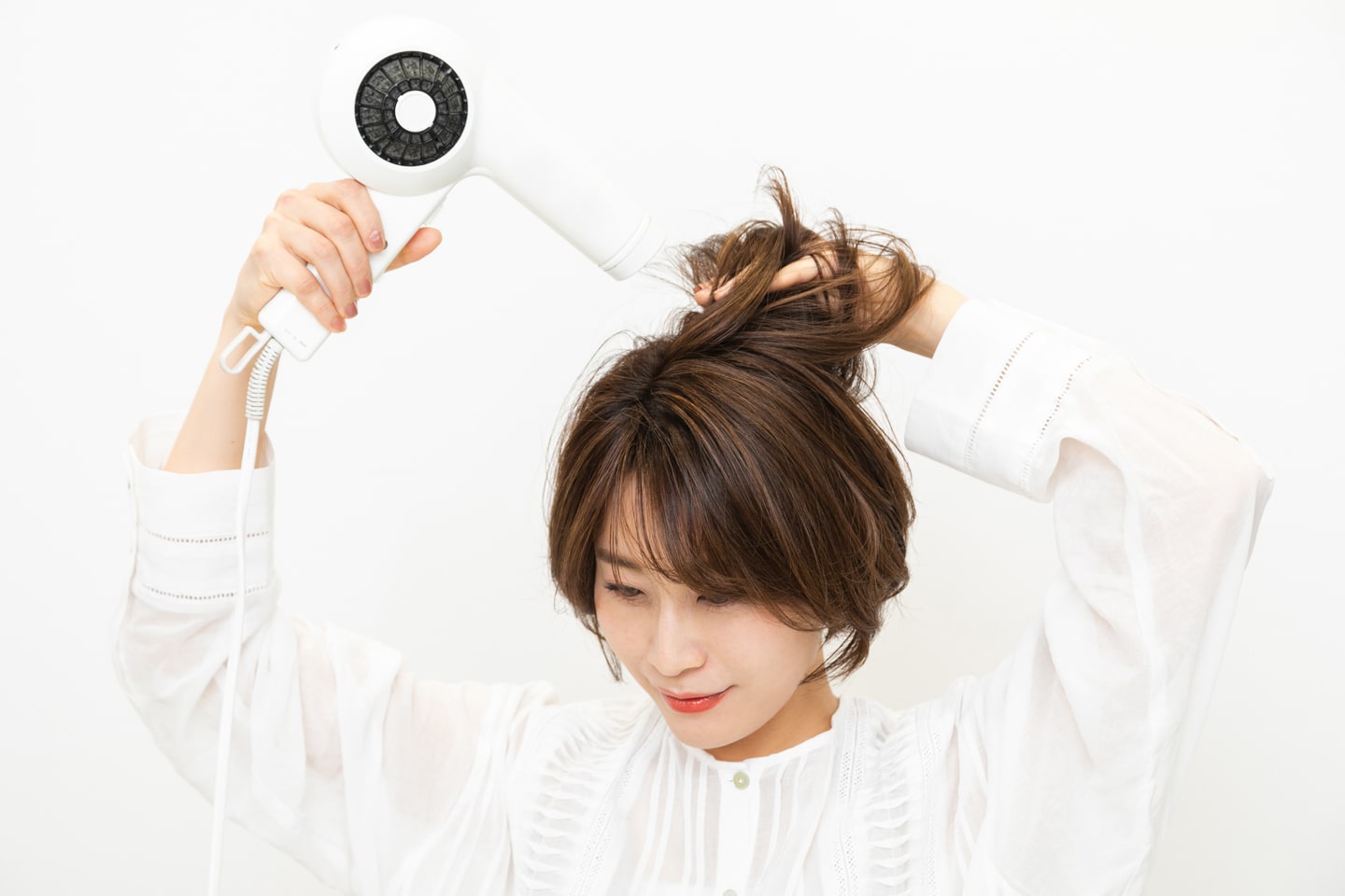 後頭部に丸みがつくように、トップの髪の根元を起こしながら乾かす。