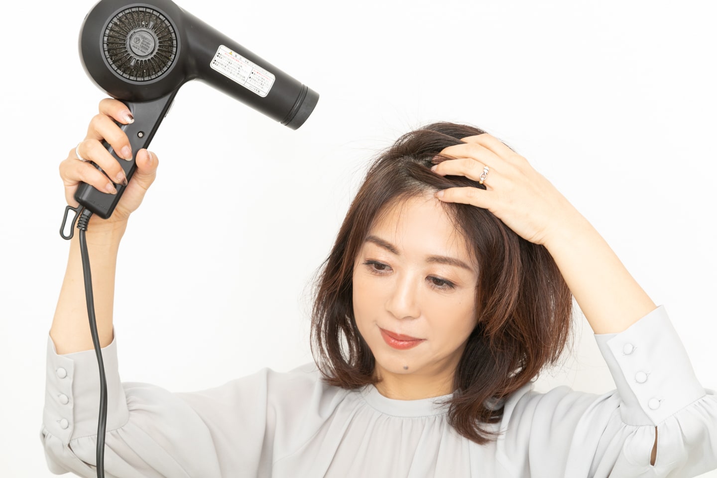 根元を、毛先が落ちる位置に逆らうように動かし、ドライヤーで乾かす。トップに高さを作り、分け目が出にくくなる。
